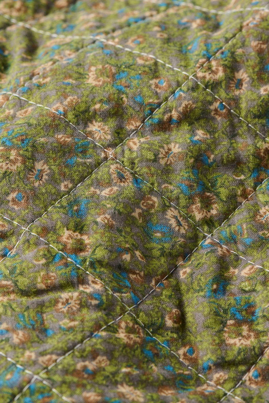 Nærbilde av småblomstret mønster på quilt fra Ib Laursen i dempede farger