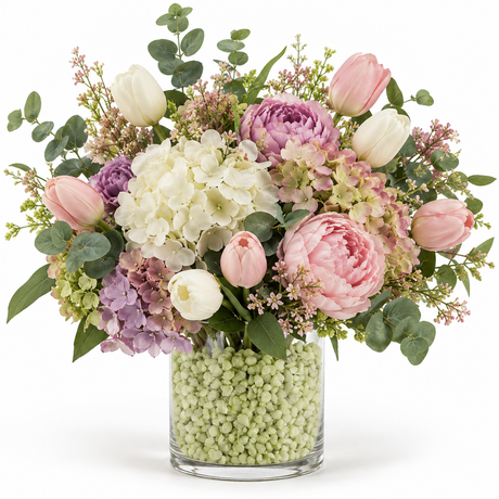 Glassvase fylt med limegrønne granulatstein og en stor bukett med blomster