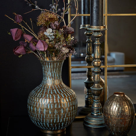 Metallvase med hamret struktur fra Speedtsberg med blomsterbukett og lysestaker