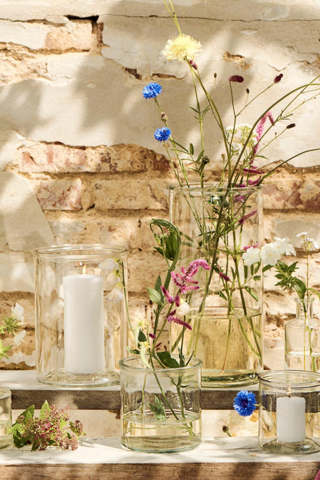 Sylinderglass fra Ib Laursen med blomster og blokklys inni