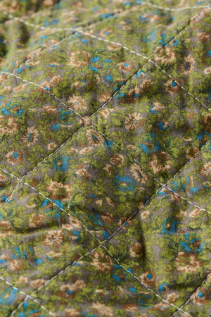 Nærbilde av småblomstret mønster på quilt fra Ib Laursen i dempede farger