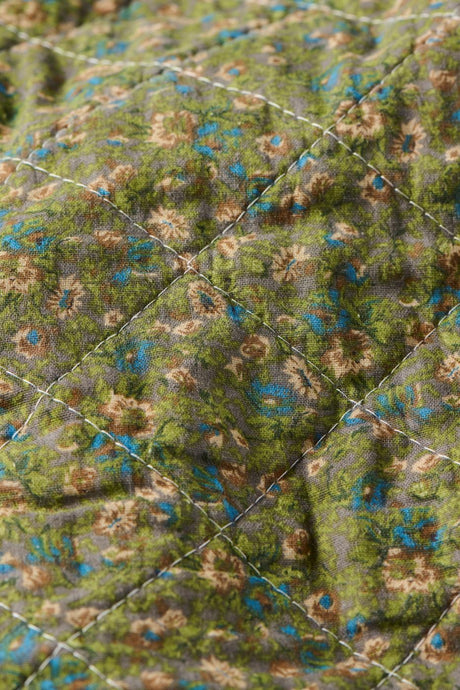 Nærbilde av småblomstret mønster på quilt fra Ib Laursen i dempede farger