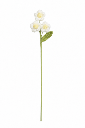 Hvit heklet blomststilk med tre små blomster, gul midte og grønt blad