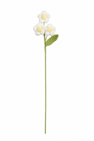 Hvit heklet blomststilk med tre små blomster, gul midte og grønt blad