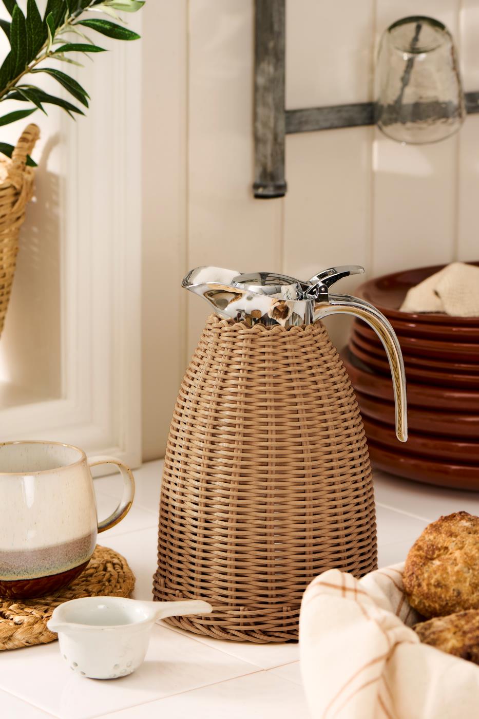 Mørkebrun flettet termoskanne fra Ib Laursen på morgenbordet med kaffekopper, brød og rustikt servise.