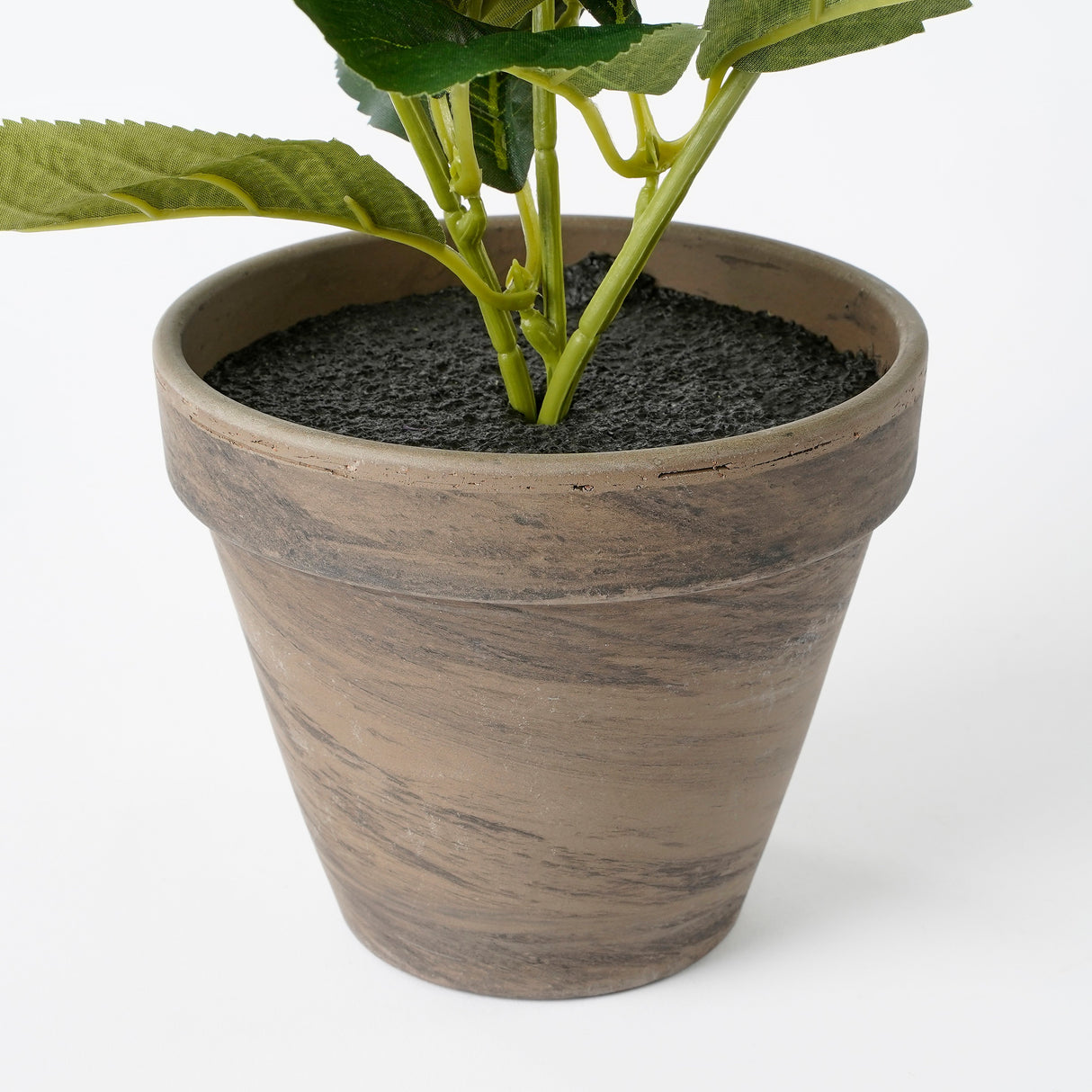 Grå lerkrukke med en kunstig hortensia i