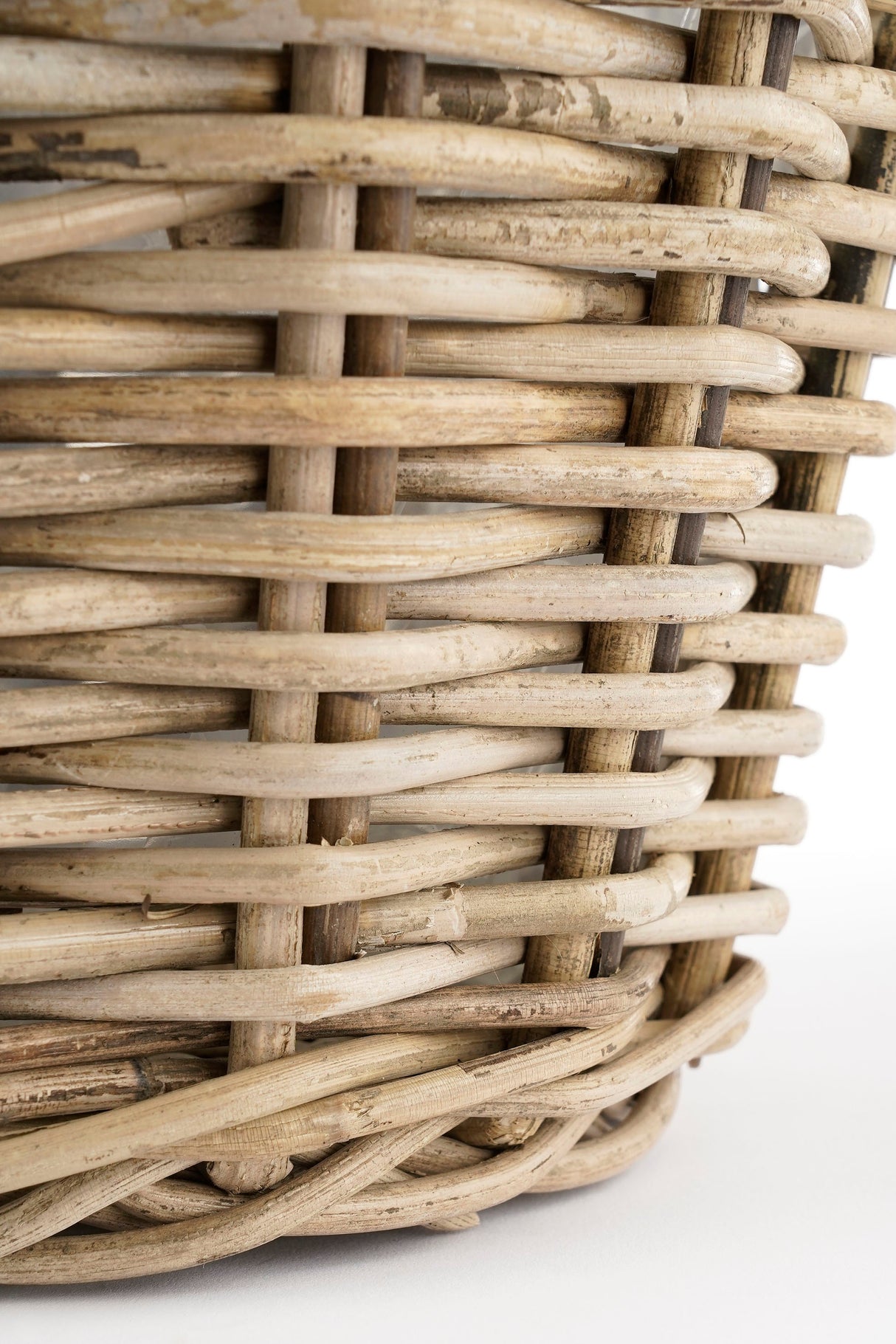 Bunden på Marcia rund kurv i grå rattan med plastinderside 