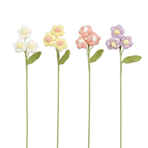 Heklede blomster med runde kronblader og gul midte i fire farger: hvit, gul, lyserosa og lilla