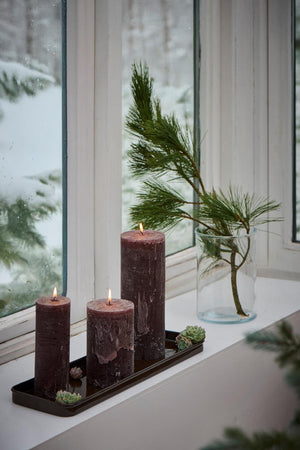 Brunt metallbrett fra Ib Laursen med tre bloklys, mose og gran som juledekorasjon i vinduskarmen