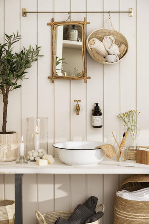 Bambusspeil fra Ib Laursen hengt over et lyst bord sammen med naturmaterialer og boligpynt