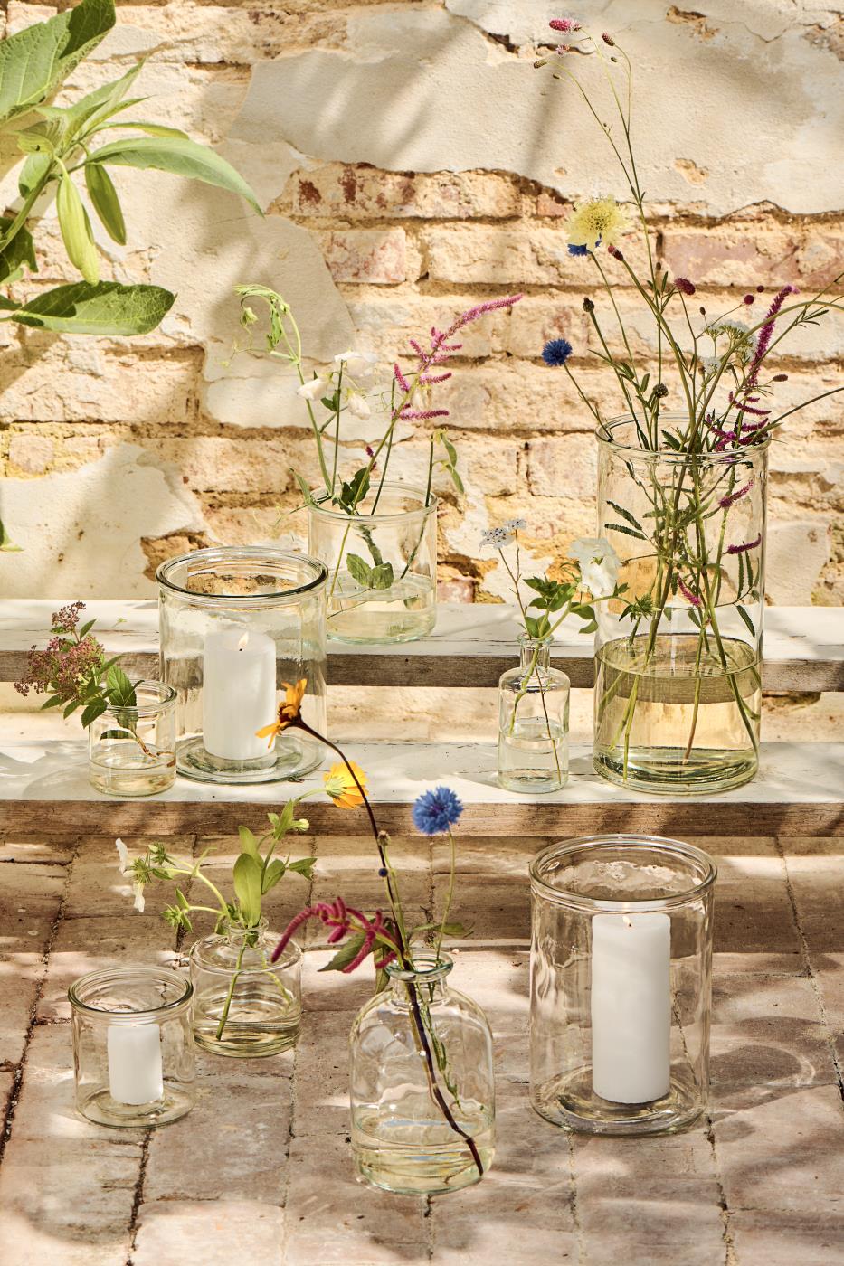 Cylindervaser med blomster og lys i på trappetrin